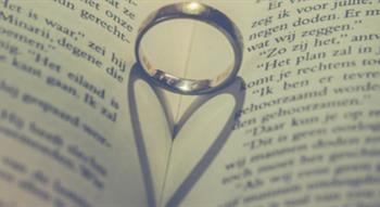 Wedding ring in page fold creating heart shape from shadow