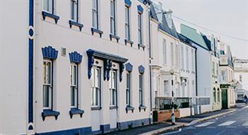 Photo of row of houses in street in sunshine