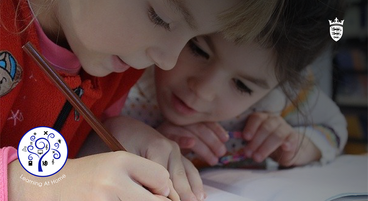 Two children lean over a piece of paper