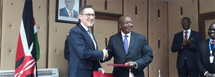 2 men shaking hands with a flag in the background 