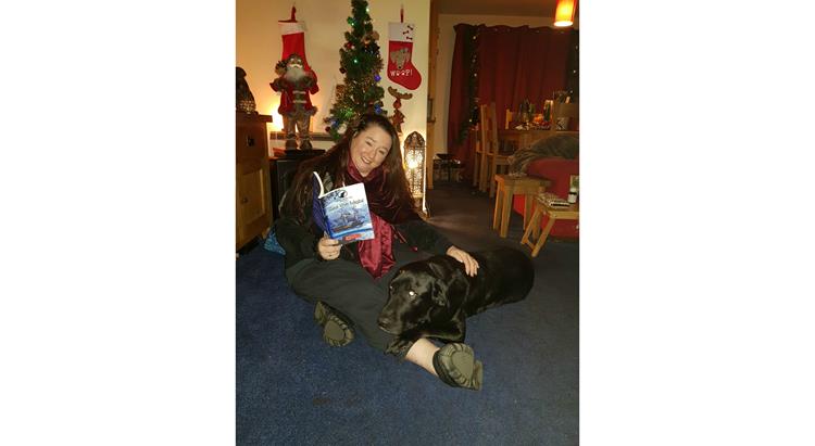 Johanna Aldridge holding a copy of her book