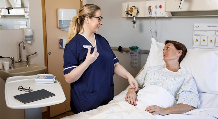 A nurse takes a woman's pulse