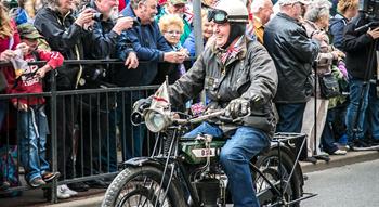 Man riding on motorbike through street