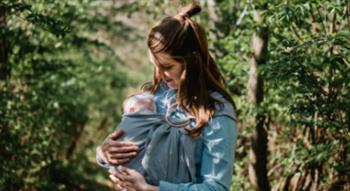 Woman holding baby in woods