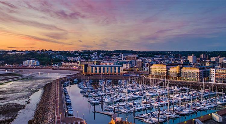 Overview of St Helier harbour and town centre at sunset