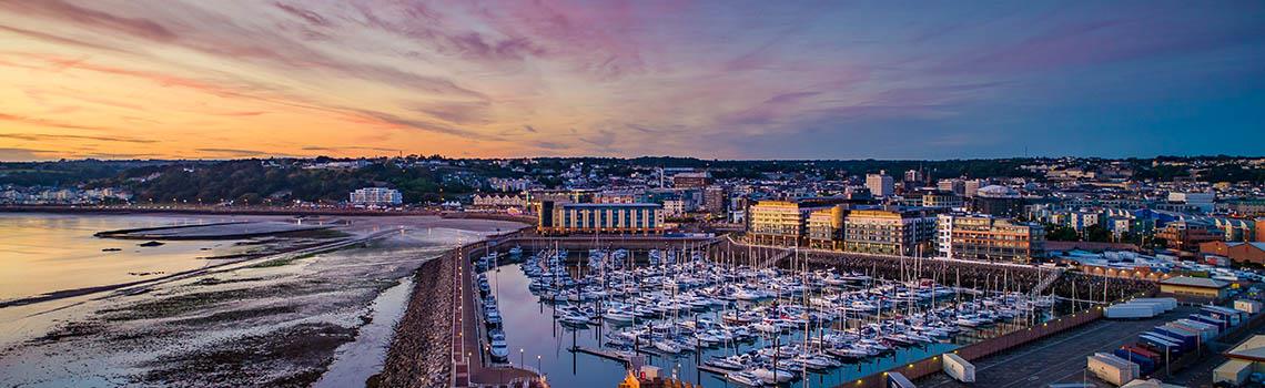 Overview of St Helier harbour and town centre at sunset