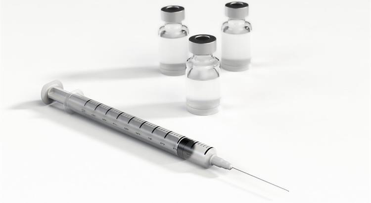 piucture of a vaccination needle and containers of vaccine