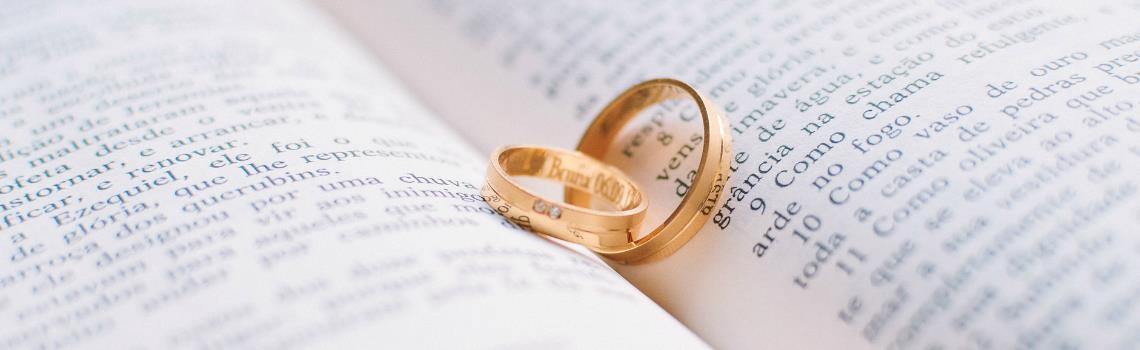 Photo of gold wedding ring placed on open book