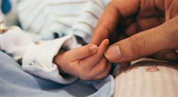 Person holding baby's hand