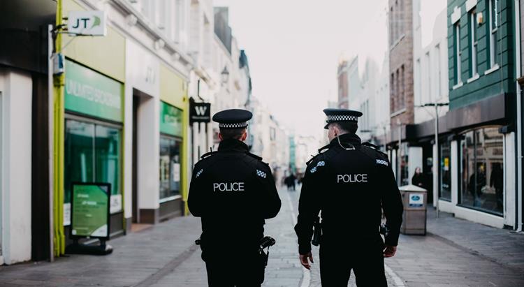 two police officers walk through st helier 