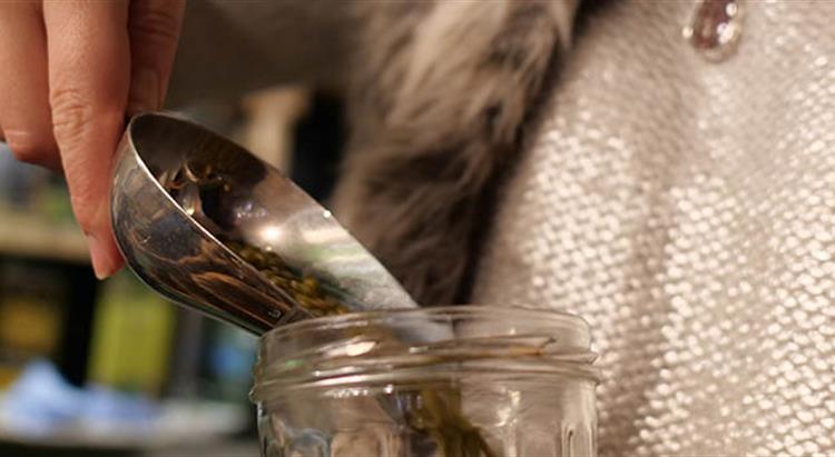 Woman pouring product in a jar