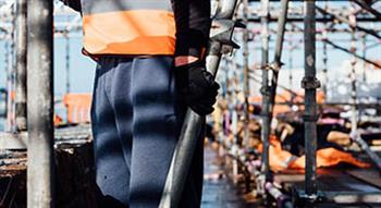 Builder holding scaffolding part