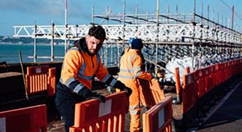 Builders moving road safety barriers