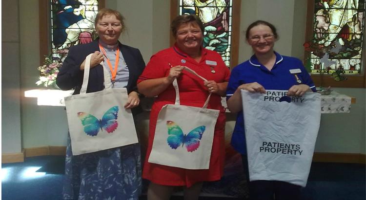 Nurses and chaplain holding dignity bags
