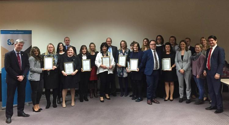 Winners stand in a row with their awards