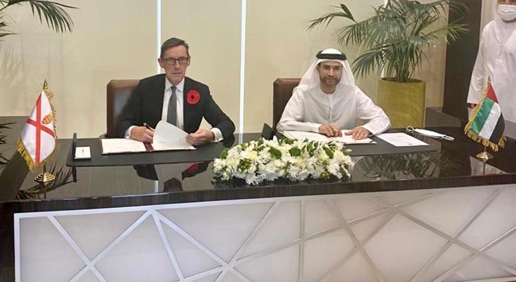 External Relations Minister, Ian Gorst and the Minister of State for Financial Affairs, His Excellency Mohammed Bin Hadi Al Husseini, sit at a table to sign a Bilateral Investment Treaty (BIT).