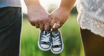 Couple holding baby booties